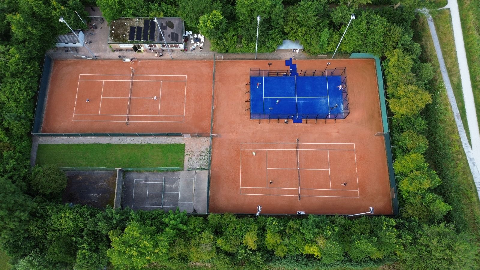 Luchtfoto van het park van L.T.C. Ferwert met gravelbanen en de padelbaan